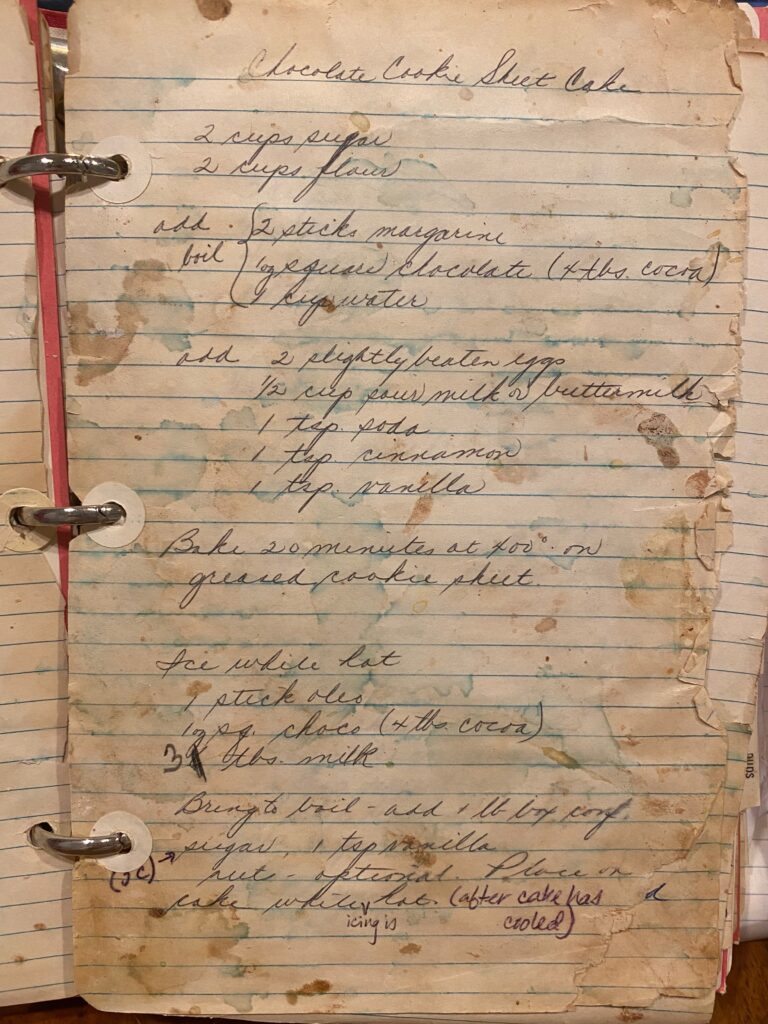 A handwritten recipe for chocolate sheet cake with food stains on the page.