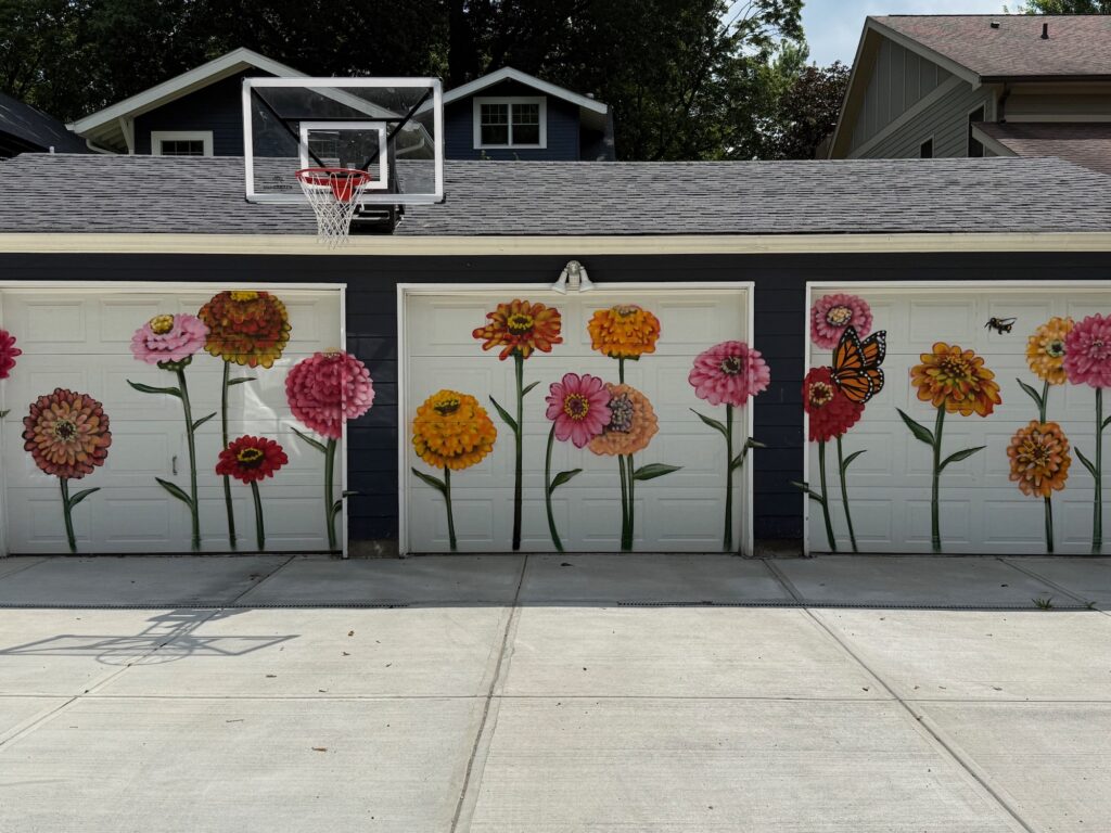 A garage with colorful flowers painted on its doors.