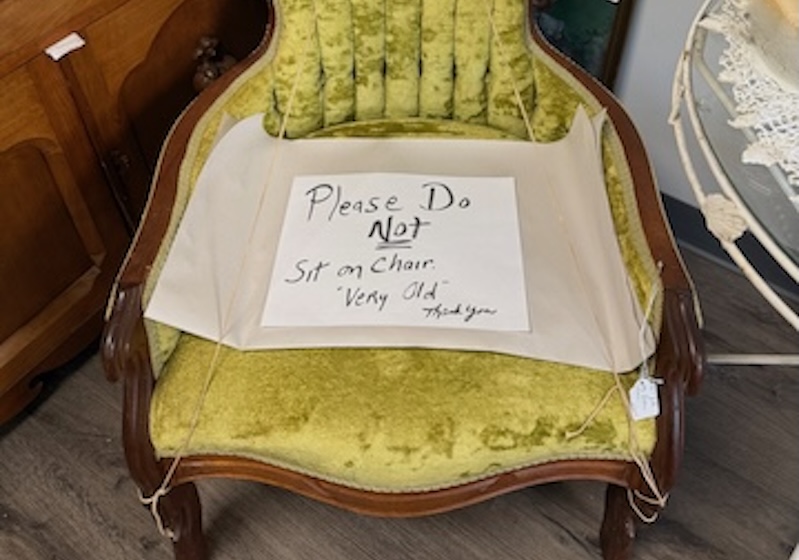 Sign reads "Please Do Not Sit on Chair Very Old Thank You"