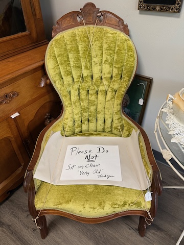 Sign on chair reads "Please Do Not Sit on Chair Very Old Thank You"