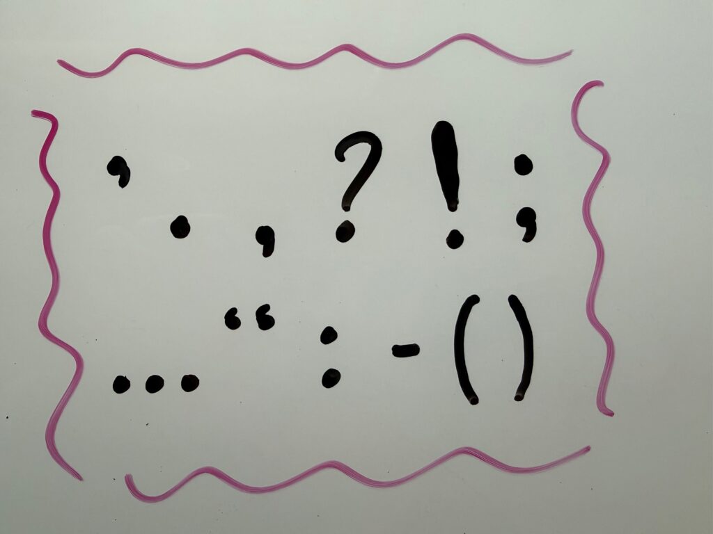 Various punctuation marks written on a whiteboard.