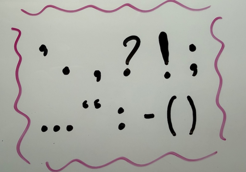 Various punctuation marks written on a whiteboard.